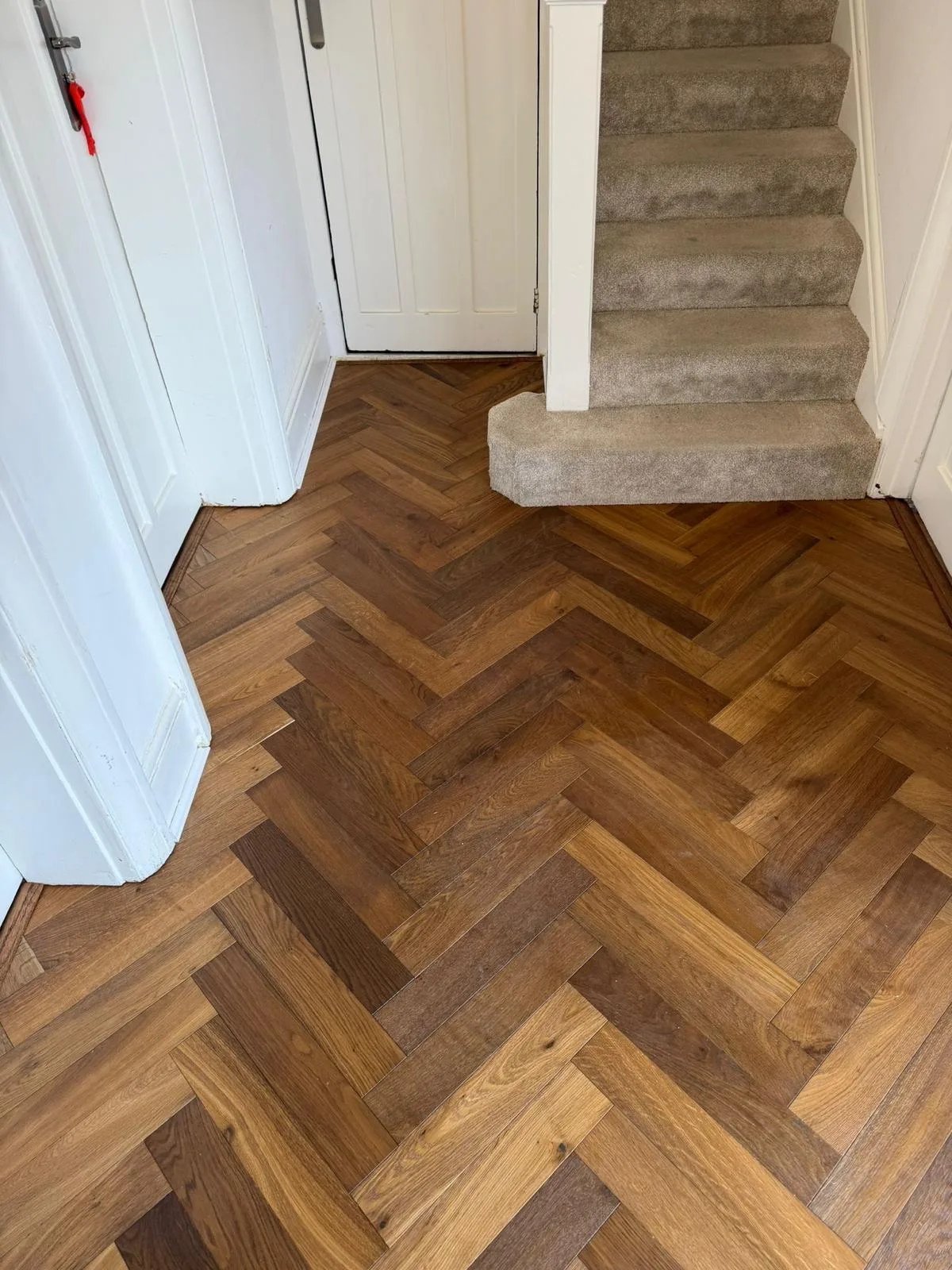American Oak Herringbone Warm Dark engineered oak flooring fitted in a hallway, Harrow