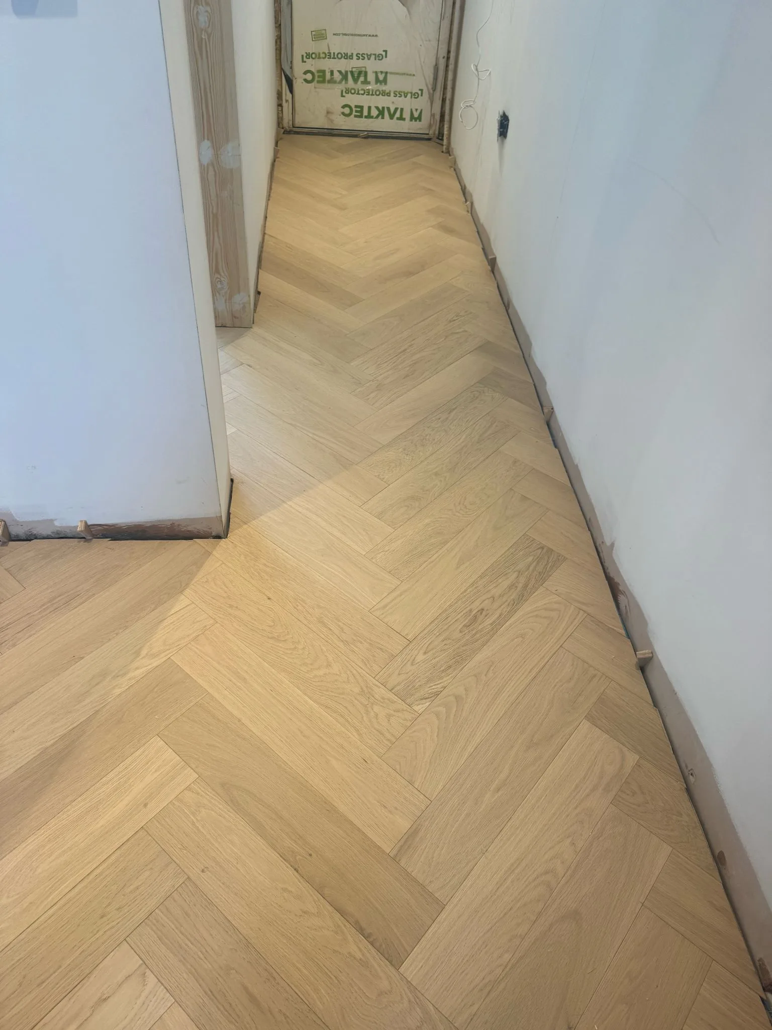 White-Oiled Oak Herringbone 90×450 engineered oak flooring fitted in a hallway, Rickmansworth