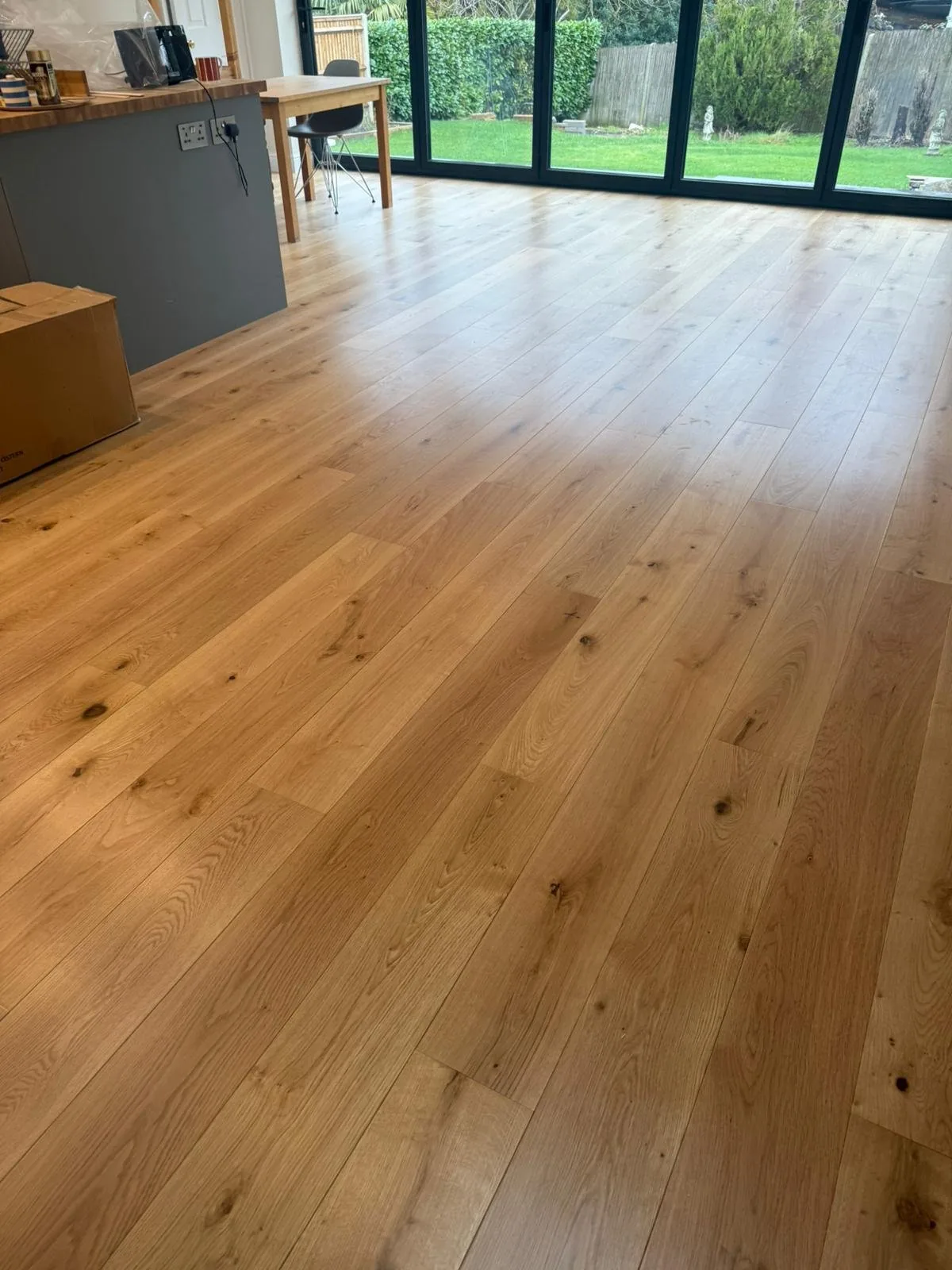 Character-grade oak flooring in an open-plan kitchen with bifold doors, Surbiton