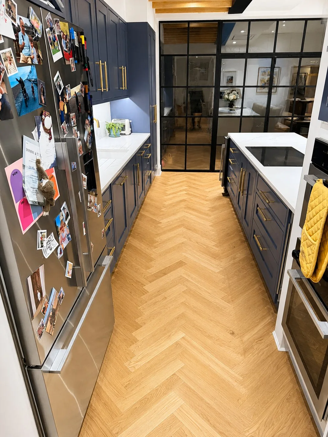 Natural oak herringbone flooring in a navy kitchen, Fulham